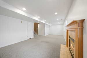 Basement with light carpet and a tile fireplace