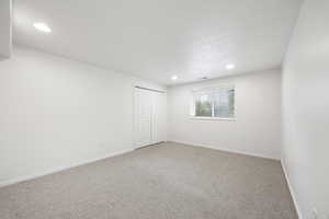 Unfurnished room with carpet flooring and a textured ceiling