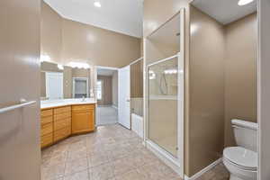 Full bathroom featuring toilet, vanity, shower with separate bathtub, and tile patterned flooring