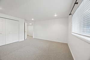 Unfurnished bedroom with light colored carpet and a closet