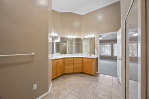 Bathroom with ceiling fan, tile patterned floors, high vaulted ceiling, and vanity