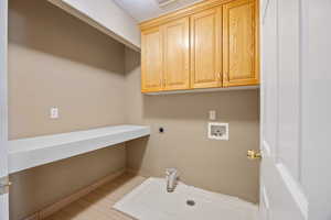 Clothes washing area featuring cabinets, washer hookup, and electric dryer hookup