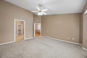 Unfurnished bedroom with ceiling fan, high vaulted ceiling, ensuite bathroom, light carpet, and a spacious closet