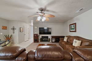 Tiled living room featuring a textured ceiling and ceiling fan