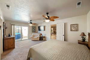 Carpeted bedroom featuring ceiling fan, a textured ceiling, and access to outside