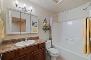 Full bathroom featuring toilet, a textured ceiling, vanity, shower / bath combo, and tile patterned flooring