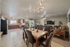 Tiled dining space with sink, a textured ceiling, and ceiling fan