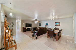 Dining area featuring ceiling fan, a textured ceiling, and light tile patterned floors