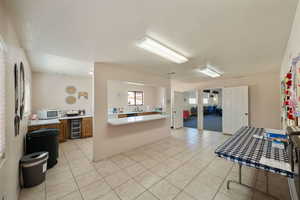 Kitchen with wine cooler, light tile patterned floors, and a wealth of natural light