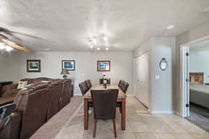 Tiled dining room with ceiling fan and a textured ceiling