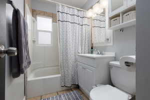 Full bathroom featuring vanity, tile patterned floors, shower / bath combo with shower curtain, and toilet