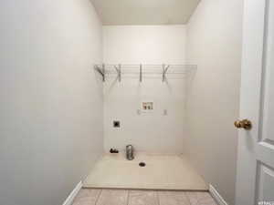 Washroom featuring light tile patterned floors, hookup for a washing machine, and electric dryer hookup