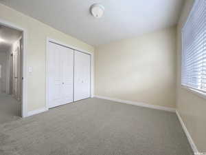 Unfurnished bedroom with carpet floors and a closet