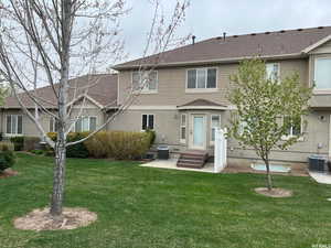 Rear view of property with central AC, a lawn, and a patio