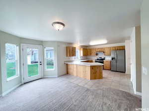 Kitchen featuring sink, a breakfast bar area, appliances with stainless steel finishes, light colored carpet, and kitchen peninsula