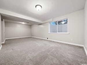 Carpeted empty room featuring a textured ceiling