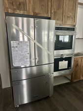 Interior details featuring double oven and dark hardwood / wood-style floors