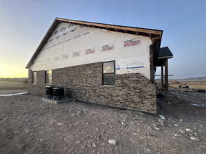 Property exterior at dusk featuring central air condition unit