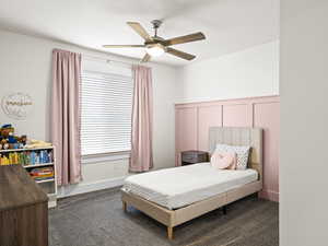 Bedroom with dark carpet and ceiling fan