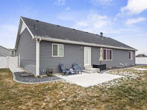 Rear view of house featuring a patio and a lawn