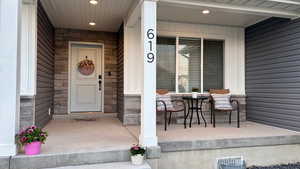 Property entrance featuring a porch and stone siding