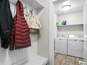 Laundry area featuring washing machine and dryer and light wood-type flooring