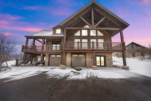 View of front of property with a garage and a deck