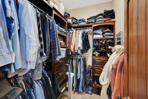 Walk in closet featuring light colored carpet