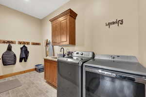 Washroom featuring cabinets, washer and clothes dryer, and sink