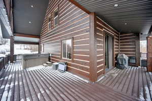 Snow covered deck with a hot tub