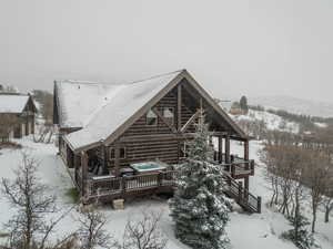 Snow covered property with a deck