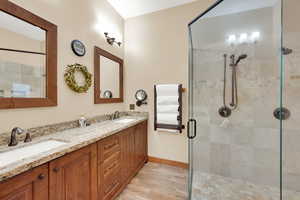 Bathroom featuring vanity, hardwood / wood-style floors, and a shower with door