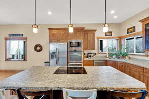 Kitchen featuring pendant lighting, stainless steel appliances, and a breakfast bar