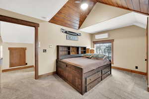 Bedroom with ceiling fan, light colored carpet, lofted ceiling, and a wall unit AC