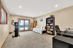 Exercise room featuring light carpet and french doors