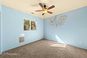 Spare room with ceiling fan and carpet