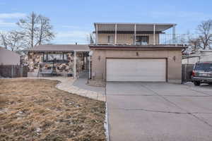 View of front of house with a garage, a balcony, and a front yard