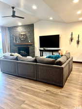 Living room with lofted ceiling & a stone fireplace.