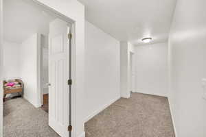 Hall featuring light colored carpet