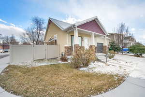 View of front of house featuring a garage, a porch, and a front yard