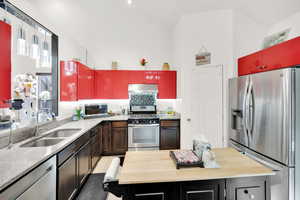 Kitchen featuring butcher block counters, sink, stainless steel appliances, and light tile patterned flooring