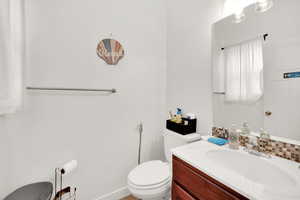 Bathroom with tasteful backsplash, vanity, and toilet