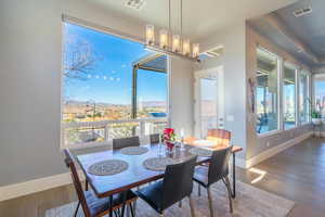 Dining space featuring wood-type flooring, plenty of natural light, a mountain view, and a chandelier