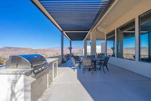 View of patio / terrace featuring a mountain view, grilling area, and an outdoor kitchen