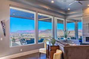 Sitting room featuring ceiling fan, a mountain view, a healthy amount of sunlight, and dark hardwood / wood-style flooring