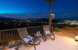 Patio terrace at dusk featuring a mountain view and a balcony