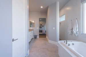 Bathroom with vanity and tiled tub