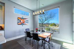 Dining space featuring dark hardwood / wood-style flooring, a mountain view, and a chandelier