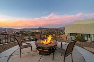 Patio terrace at dusk featuring a mountain view and a fire pit