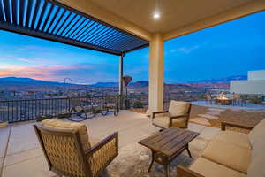 Patio terrace at dusk featuring a mountain view and an outdoor living space with a fire pit